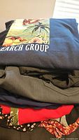 Stack of folded new garments topped by graphic T-shirt