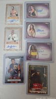Front view of all seven autographed wrestling trading cards in sleeves