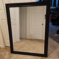 Front view of rectangular mirror leaning against wall
