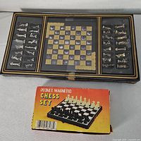 Black and gold case with built-in board and boxed pocket magnetic chess set