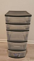 Front view showing five clear drawers and black top