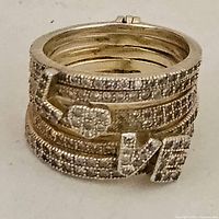 Angled view showing front pavé bands, heart and LOVE letters