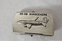 Front of belt buckle showing aircraft and text