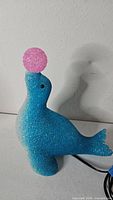 Front view of blue popcorn plastic seal lamp with pink ball