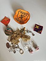 Overview of all items: assorted jewelry pieces and three Poco cloth patches