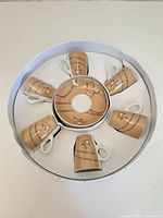 Top view of boxed cappuccino cup and saucer set showing six cups around stack of saucers in original packaging