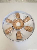 Boxed cappuccino set showing six cups arranged around stacked saucers