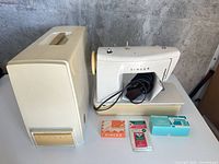 Singer sewing machine with case and accessories displayed