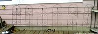 Full set of linked black metal fence sections against siding