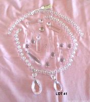 All chandelier parts laid out on pink cloth
