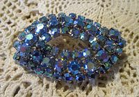 Front view showing layered rows of blue AB rhinestones on rhodium plate