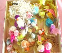 Open box showing multiple small chenille chicks and birds in shredded paper