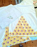 Two crochet-trim pillowcases and one embroidered pillowcase displayed