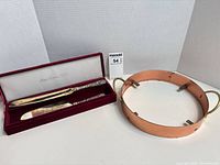 Knives in presentation box alongside copper ring holder