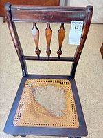 Top view of chair showing damaged woven cane seat and backrest design