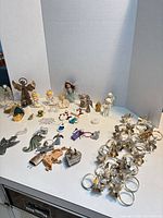 All items grouped; visible metal napkin rings, figurines, ornaments