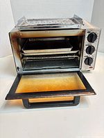 Front view of toaster oven with door open showing interior, bake pan and rack