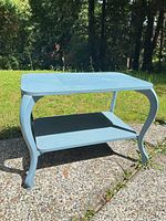 Front view of light blue two-tier side table on outdoor surface