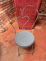 Full view of metal bistro chair showing heart backrest and overall structure