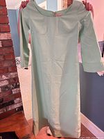 Front view of mint dress on hanger showing full length, sleeves, neckline