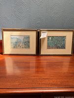 Both framed prints side by side on surface