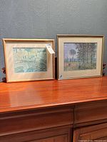 Both framed prints side by side on furniture