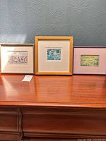 All three framed artworks side by side on table
