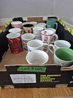 Group of assorted mugs in produce box
