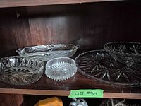 Overview of multiple clear glass serving pieces on shelf