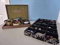 Open wood jewelry box with assorted bangles, bracelets and closed storage tray