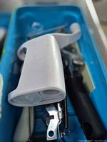 close-up of assorted small tools including white plastic gadget, peeler and knives