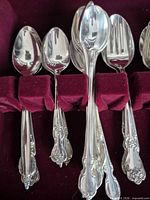 assorted spoons showing ornate handles in chest