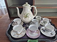 Full set on tray showing teapot, cups, saucers, infuser