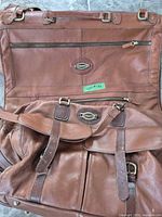 Open Bugatti leather garment or duffel bag showing exterior pockets and straps