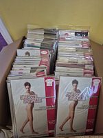 Open box containing numerous sealed pantyhose packages