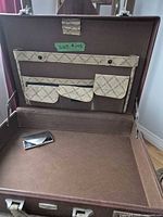 Open Carl Weill briefcase showing brown interior, organizer pockets, and card holder