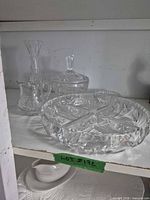 Five clear cut glass pieces on shelf