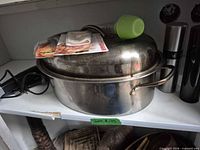 Roasting pan with lid, rack inside, stuffing bag kit and green mister top visible