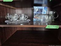Overall lot on shelf showing all glass pieces and packaged napkins