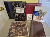 Group shot of all six photo albums standing and lying flat