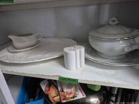 Platter, gravy boat, salt & pepper shakers, covered tureen with underplate on shelf