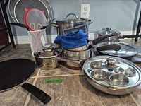 Group shot of all cookware pieces, lids, utensils, holder and strainers