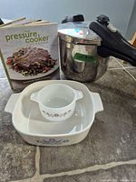 All items grouped: pressure cooker, cookbook, CorningWare dish, small ramekin