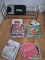 Overall lot with wire rack, stacks of Christmas CDs, cassette tape