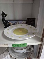 Front view of Gibson cat plate with figurine and sign behind