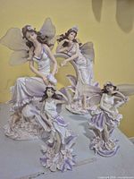 Four resin fairy figurines displayed together