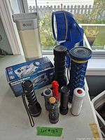 Group view of OttLite lamp, blue spotlight, black flashlights, mechanical flashlights and packaging