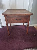 Front view of walnut veneer nightstand showing drawer and tapered legs