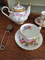 Teapot, infuser and teacup with saucer