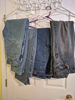 Four pairs of jeans hanging to show color range and general condition